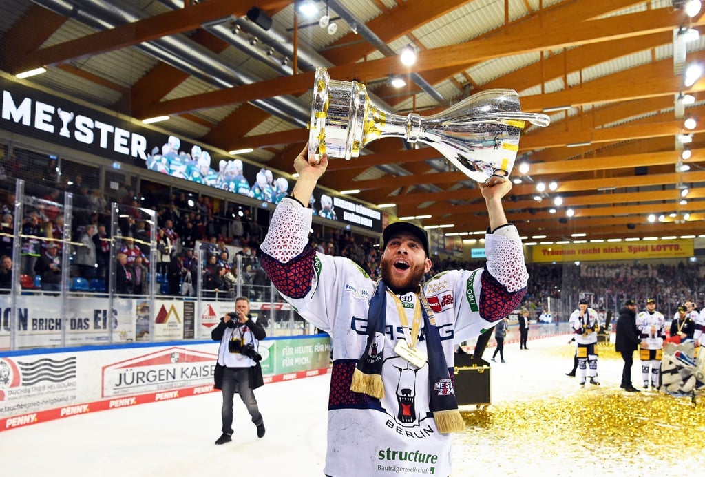 Berlins Yannick Veilleux jubelt nach dem Gewinn der deutschen Eishockey-Meisterschaft mit dem Pokal.