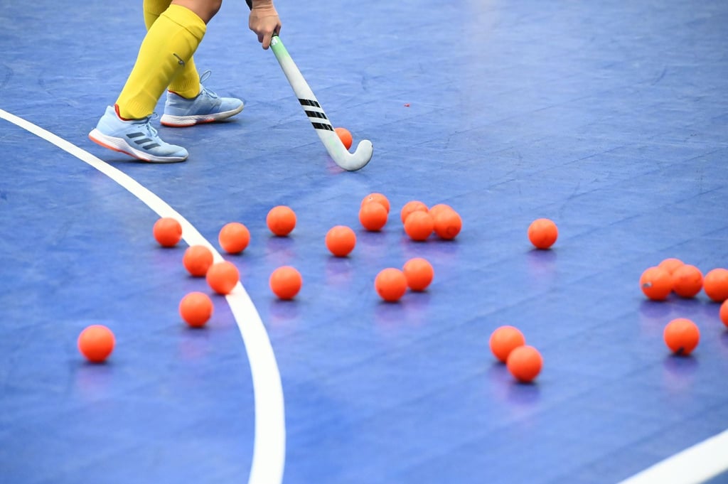 Mehrere Hockeybälle liegen während eines Trainings auf dem Feld.