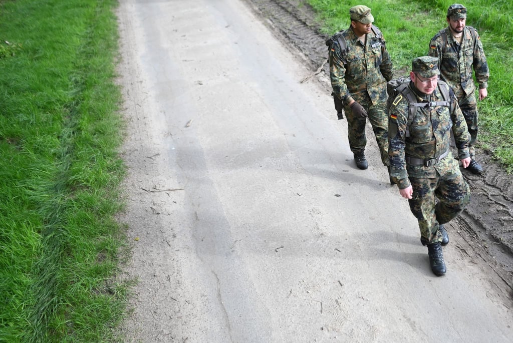 Soldaten der Bundeswehr gehen einen Waldweg entlang, nachdem sie ein Waldstück abgesucht haben.