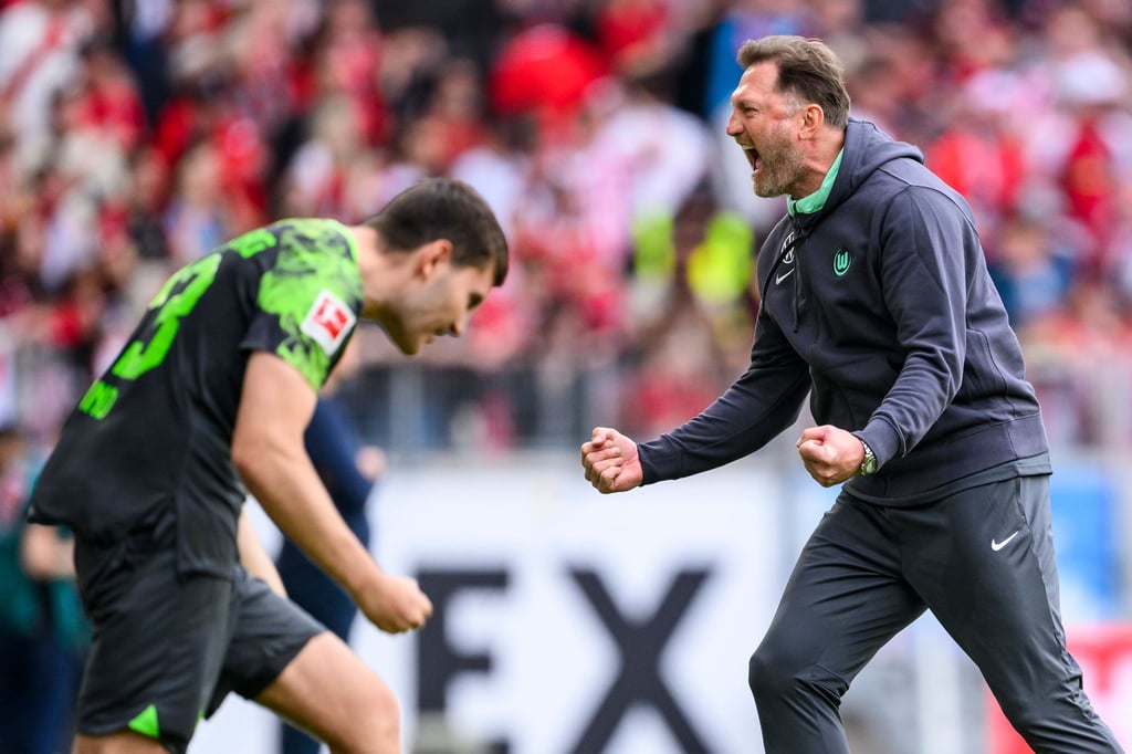 Wolfsburgs Trainer Ralph Hasenhüttl (r) jubelt nach dem Spiel mit Wolfsburgs Jonas Wind (l).