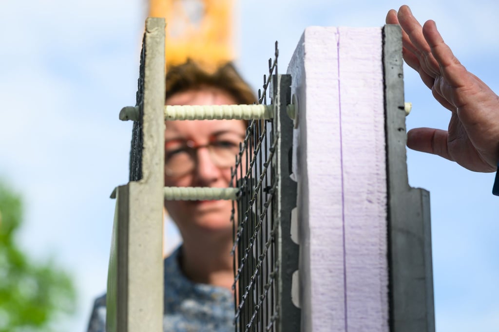 Klara Geywitz (SPD), Bundesministerin für Wohnenbetrachtet während ihres Besuchs in Sachsen auf der Baustelle zum Bau des ersten öffentlichen Gebäudes mit Carbonbeton eine Betonplatte mit Carbon.