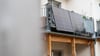 Eine Balkonsolaranlage hängt an einem Wohnhaus. Mit der richtigen Ausrichtung kann man kräftig Stromkosten einsparen.