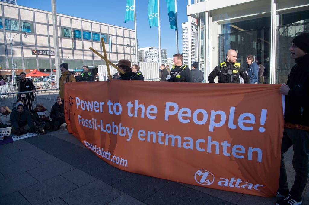 Attac-Aktive blockieren mit einem Transparent das Berliner Congress Center (BCC).