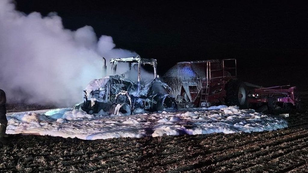 Der ausgebrannte und gelöschte Traktor auf einem Feld in Derenburg.