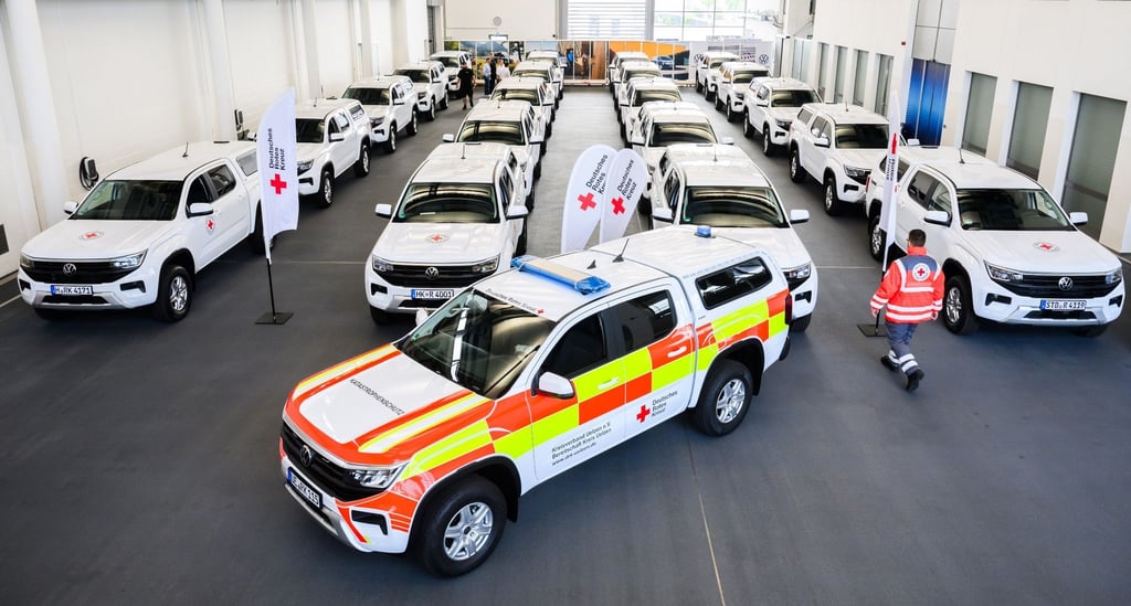 Ein Helfer vom Deutschen Roten Kreuz DRK steht bei der Übergabe von 22 Geländewagen von Volkswagen Nutzfahrzeuge.