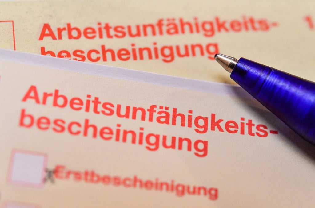 Eine Arbeitsunfähigkeitsbescheinigung liegt auf einem Tisch.