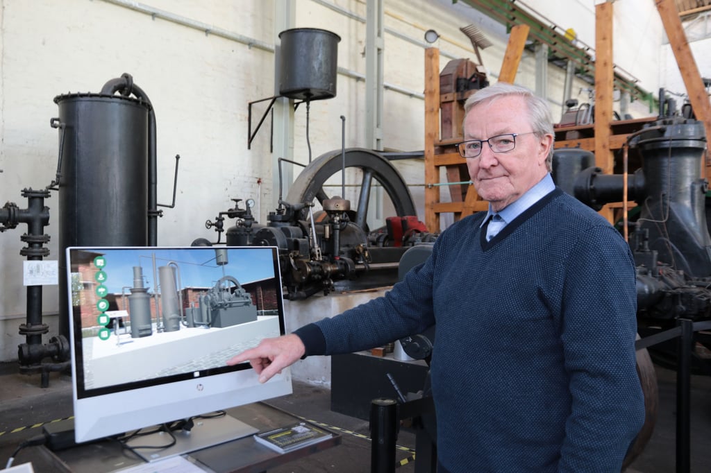 Reinhard Schenkewitz, Vorsitzender des Fördervereins des Technikmusems, zeigt auf einen der interaktiven Bildschirme.