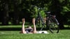 Ein Mann liegt auf einer Wiese und sonnt sich. Es wird sommerliches Wetter in Deutschland erwartet.