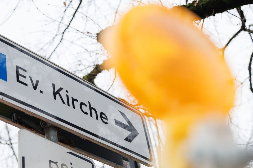 Blick auf ein Verkehrsschild mit der Aufschrift „Ev. Kirche“.