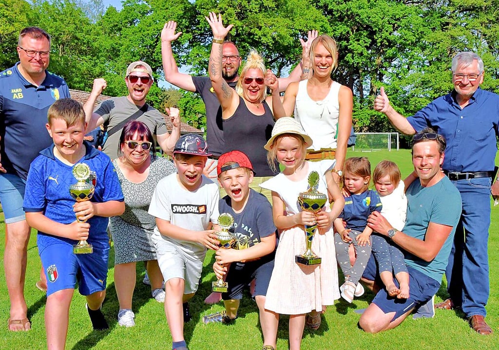 SG-Vorsitzender Andy Berck (l.) und Bürgermeister Hubertus Nitzschke (r.) übergeben die Pokale an die Sieger-Familien: Toni und Silvi Rimke (Mitte; hinten) mit Sohn Paul (vorn; l.), Sophia und René Müller mit Anton und Til (Mitte; vorn) sowie Julia und Steffen Helmuth mit Töchtern Hanna und Greta sowie Freundin Charlotte.
