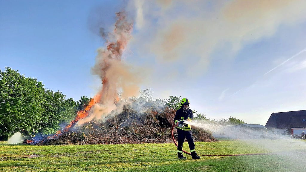 Die Kameraden der Feuerwehr bewässerten Wiese und Bäume am Rande des Feuers in Gorsdorf. Weil der abgebrannte Haufen noch etwa drei Tage lang glimmen kann, kontrollieren ihn die Feuerwehrleute noch regelmäßig.