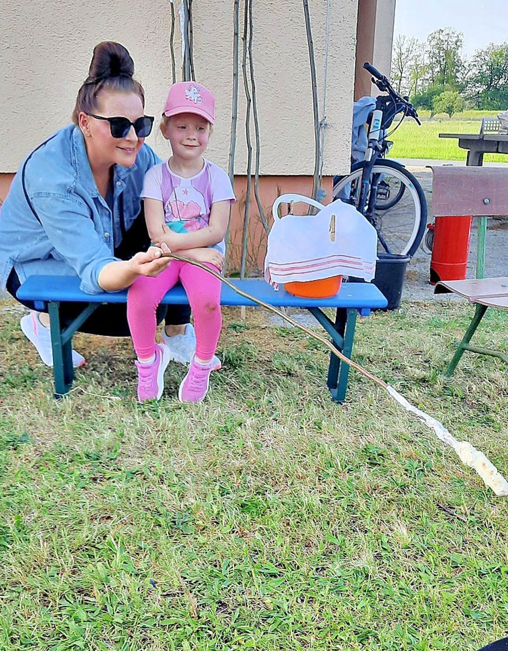 Die vierjährige Emma hält mit ihrer Mutter Kathleen Block Stockbrot über ein kleines Feuer.
