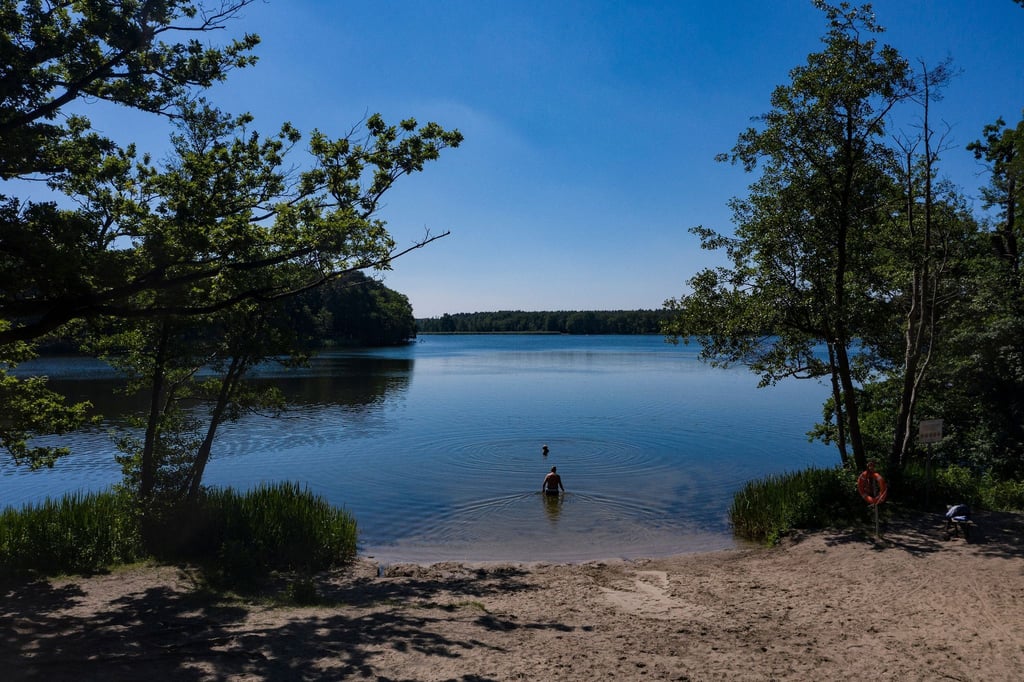 Menschen genießen das schöne Wetter am Grabowsee unweit von Oranienburg.