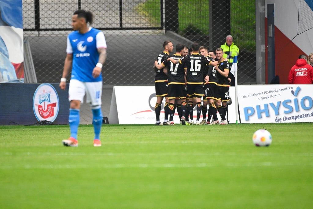Die Karlsruher Spieler feiern den Sieg bei Hansa Rostock.