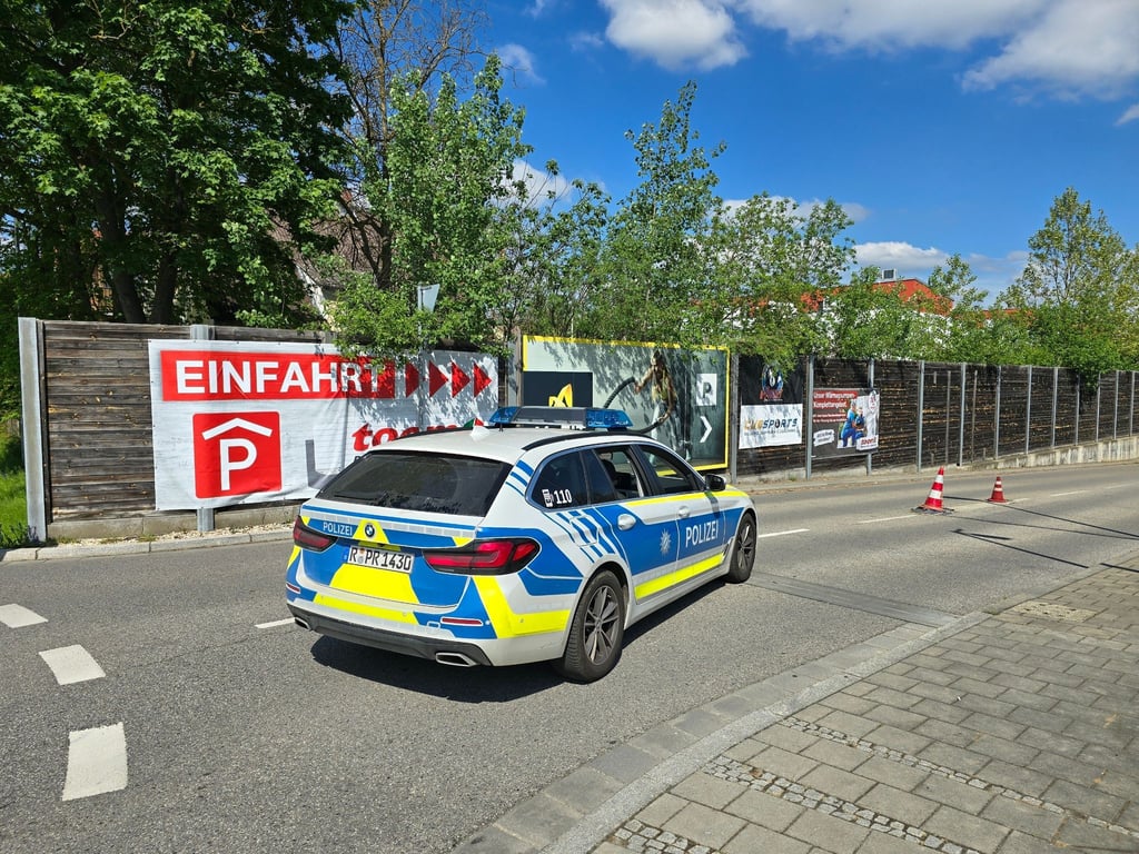 Ein Polizeiauto steht in der Zufahrt zur Tiefgarage eines Baumarkts, wo die Leiche einer Frau im Kofferraum eines Autos gefunden worden ist.