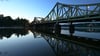 Die Glienicker Brücke spiegelt sich am Morgen im Wasser der Havel.