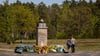 Zahlreiche Blumenkränze liegen um einen Gedenkstein auf dem Gelände der Gedenkstätte Bergen-Belsen.