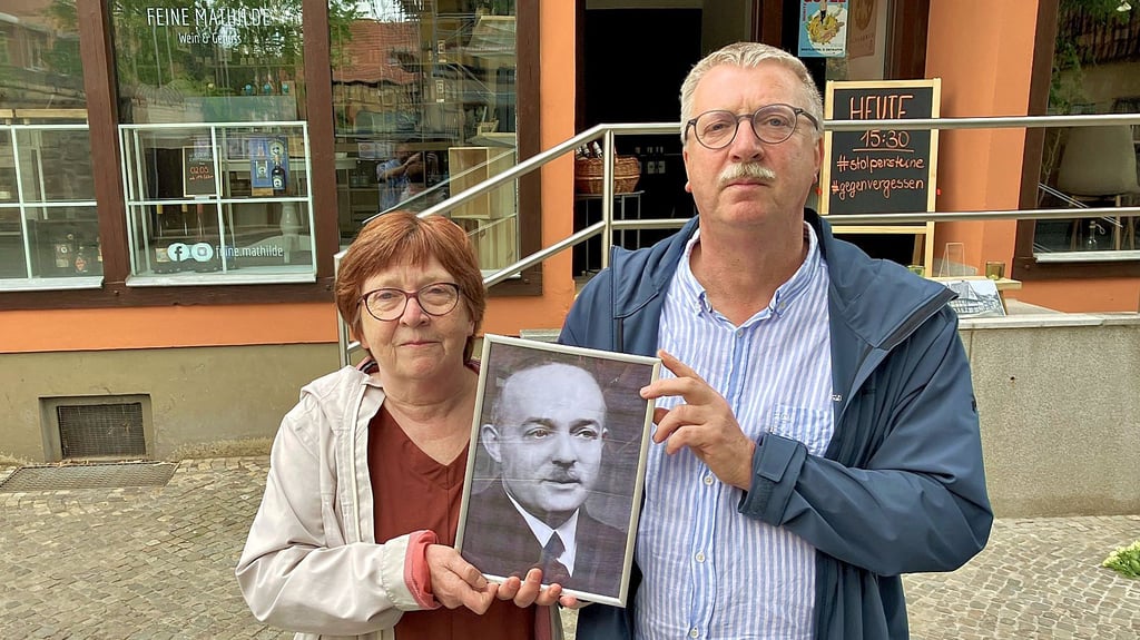 Annette Koretzky-Vogt und Felix Koretzky mit einem Foto ihres Großvaters vor dem Eckhaus, in dem Julius Koretzky arbeitete.