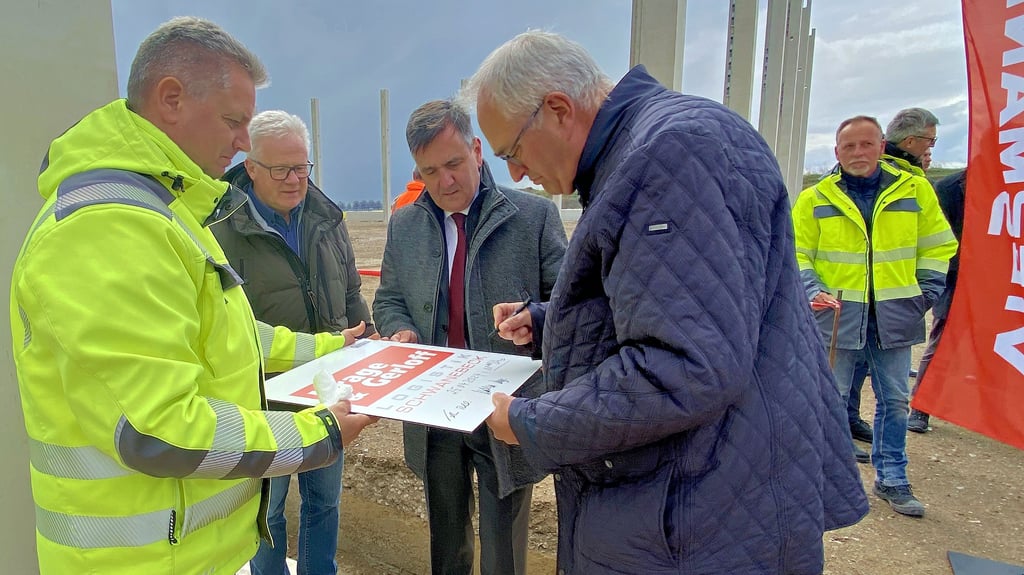 Nach der Grundsteinlegung für eine weitere neue Halle bei Krage & Gerloff in Schwanebeck (Landkreis Harz) unterschreiben Mathias Krage, Landrat Thomas Balcerowski, Planer Olaf Herbst (von rechts) und weitere Partner ein Erinnerungsschild.