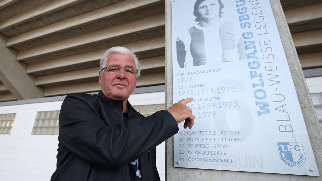 Wolfgang Seguin neben seinem FCM-Legenden-Schild in der MDCC-Arena: Er schoss Magdeburg 1974 zum Finalsieg gegen den AC Mailand im Europapokal.
