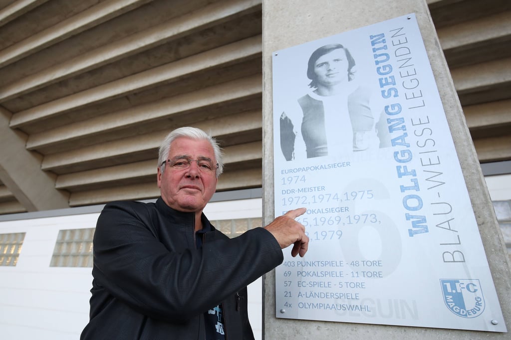 Wolfgang Seguin neben seinem FCM-Legenden-Schild in der MDCC-Arena: Er schoss Magdeburg 1974 zum Finalsieg gegen den AC Mailand im Europapokal.