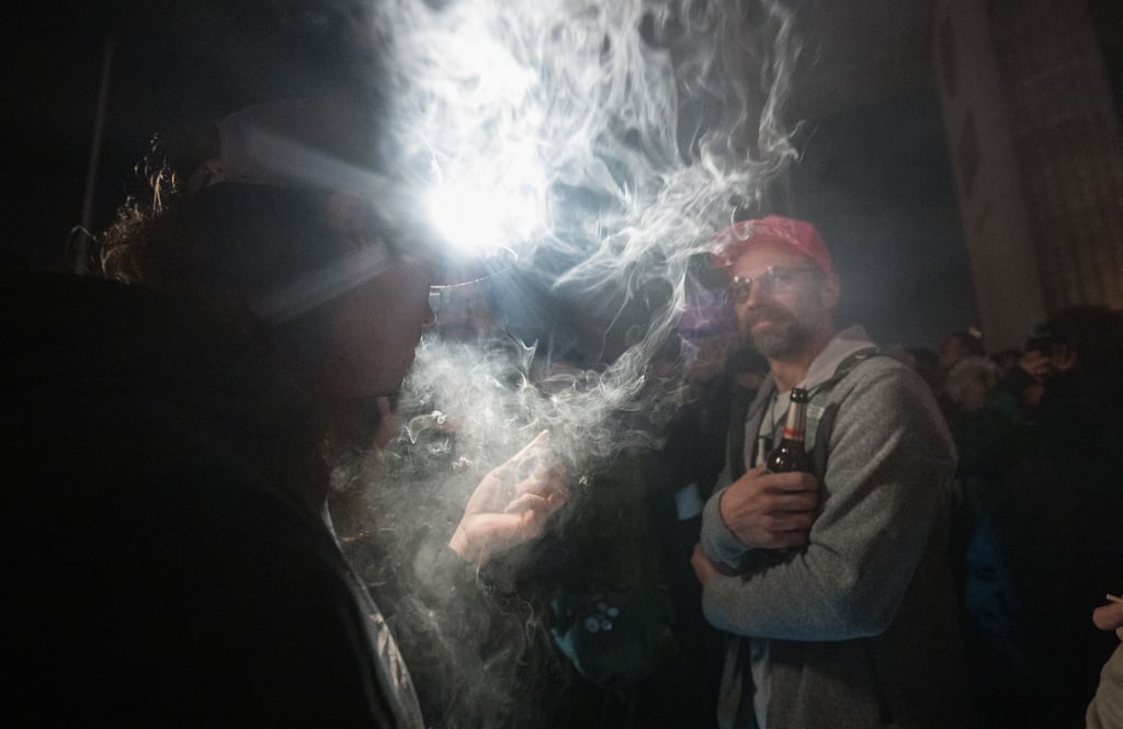 Teilnehmer rauchen während eines „Smoke In“ vor dem Brandenburger Tor Cannabis.