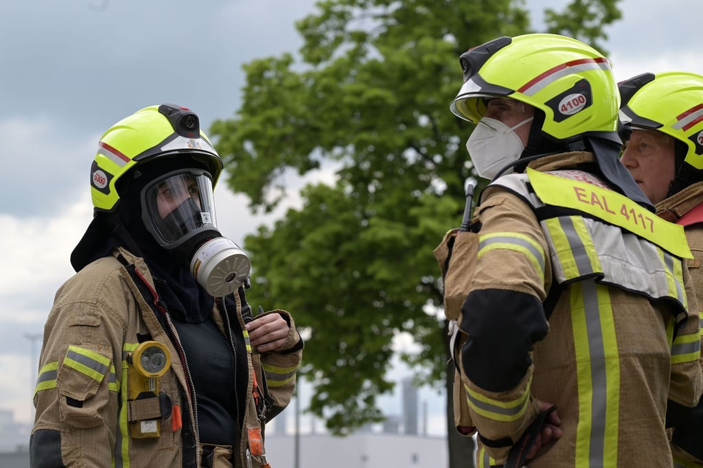 Feuerwehrleute beraten sich während des Brandes einer Fabrik in Berlin-Lichtenfelde.
