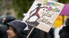 „Demokratie jetzt schützen“ ist auf dem Schild einer Teilnehmerin einer Demo gegen rechts zu lesen.