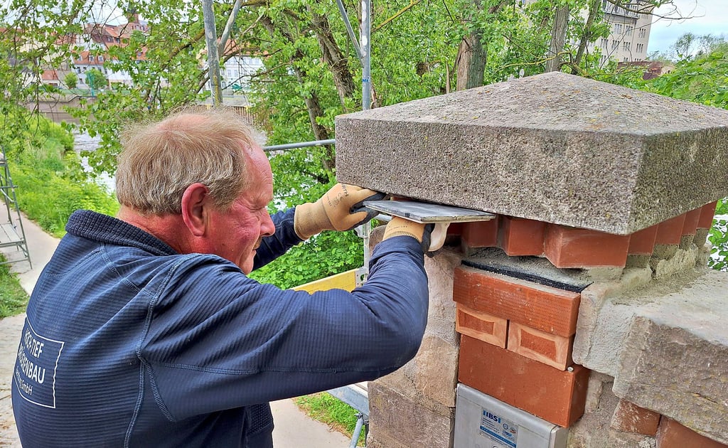 Jürgen Winselmann von der Firma HTB verfugt das Mauerwerk am Treppenaufgang der Kaimauer.