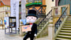 Mr. Monopoly posiert mit einer Dummyverpackung des Spiels vor dem Rathaus in Wernigerode.
