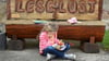 Ein Kind sitzt lesend vor der "Lese-Lust"-Bank an der Schule in Mügeln. Das Kultusministerium verlängert das Projekt „Lesescouts“ der Stiftung Lesen um zwei weitere Jahre (2024 und 2025) und unterstützt es finanziell mit 50.000 Euro.