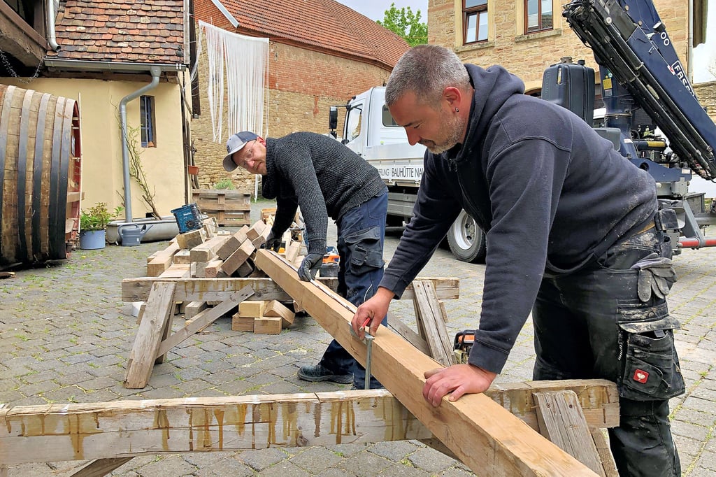 Stefan Malzer und Stephan Schütze (v.l.) schneiden Holzbalken zu, mit denen das Stallgebäude der Stadtmühle im Erdgeschoss abgestützt wird.