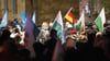 Teilnehmer einer Kundgebung der rechtsextremen Kleinstpartei Freie Sachsen gehen mit verschiedenen Fahnen eine Straße entlang.