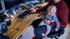 Ein junger Vater im Home-Office mit seinem sechs Monate alten Sohn.