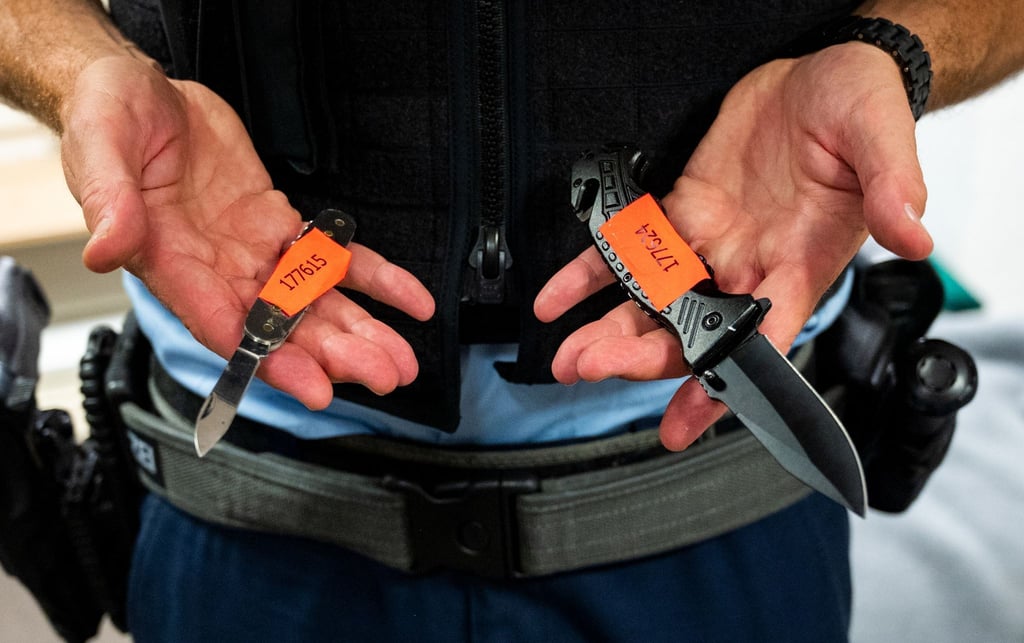 Ein Bundespolizist zeigt sichergestellte Messer.