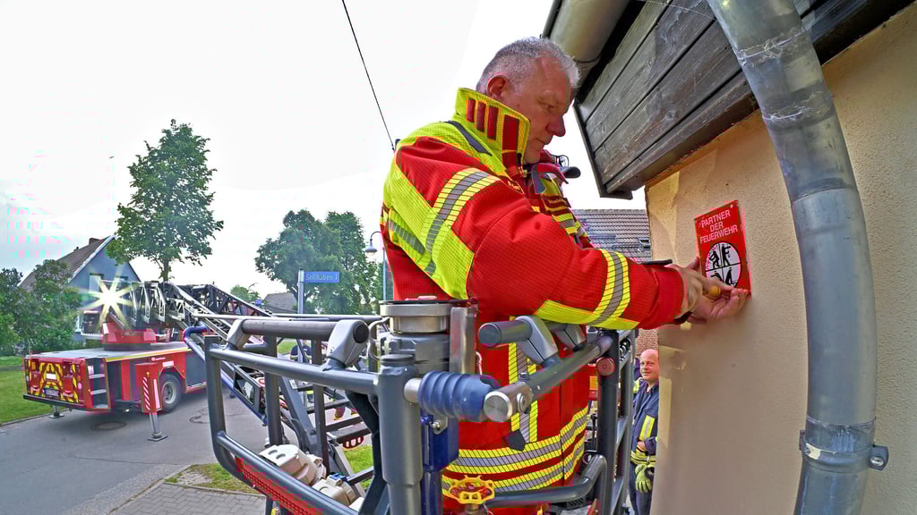 Die Plakette „Partner der Feuerwehr“ wird angebracht.