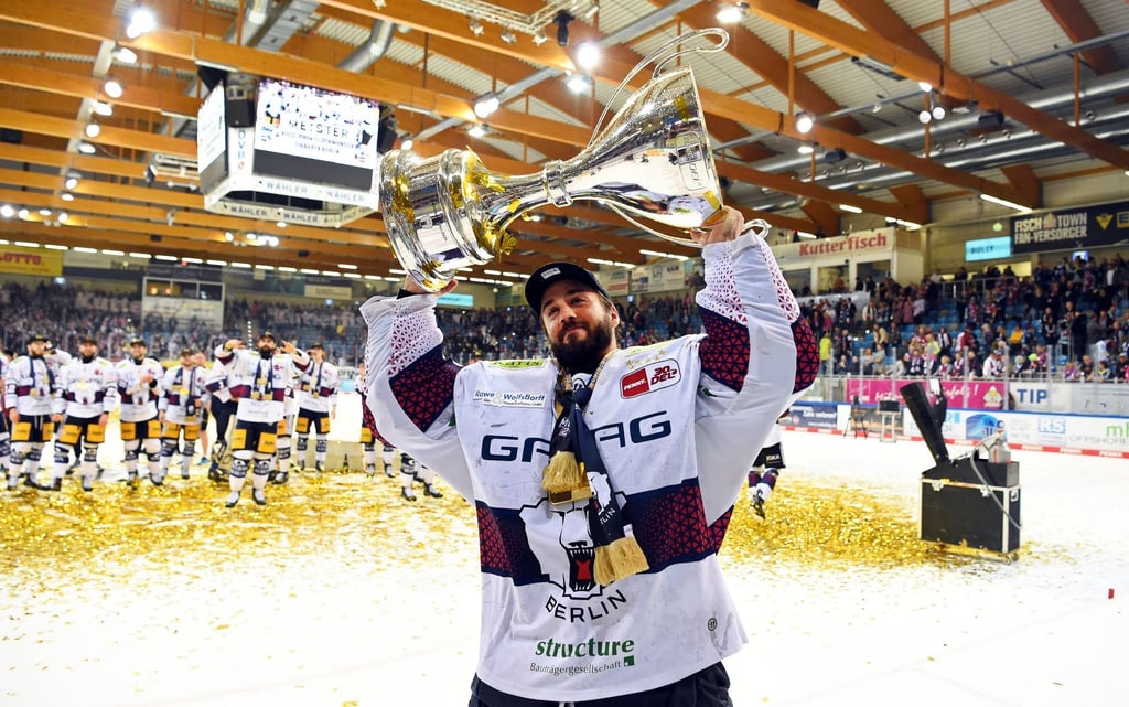 Berlins Torwart Jake Hildebrand jubelt nach dem 2:0-Sieg und dem Gewinn der deutschen Eishockey-Meisterschaft mit dem Pokal.