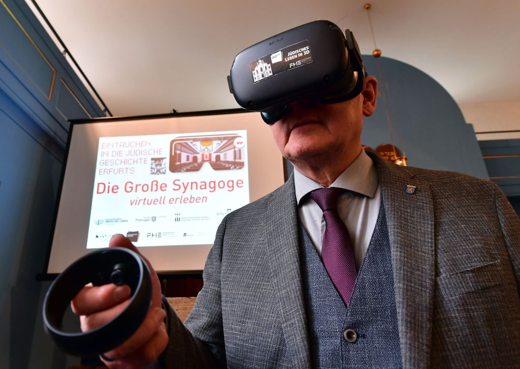 Bodo Ramelow (Die Linke), Ministerpräsident von Thüringen, besichtigt 2021 während einer Pressekonferenz der Jüdischen Landesgemeinde mit Controller und VR-Brille die virtuell rekonstruierte Große Synagoge Erfurt.