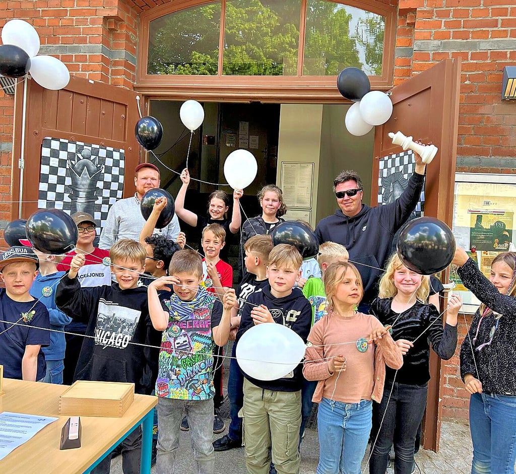 Zur Feier des Tages ließen die Kinder der Schach-AG mit ihren Leitern Max Hartmann (hinten links) und Marius Friedrich (hinten rechts) Ballons in Magdeburg-Olvenstedt steigen.