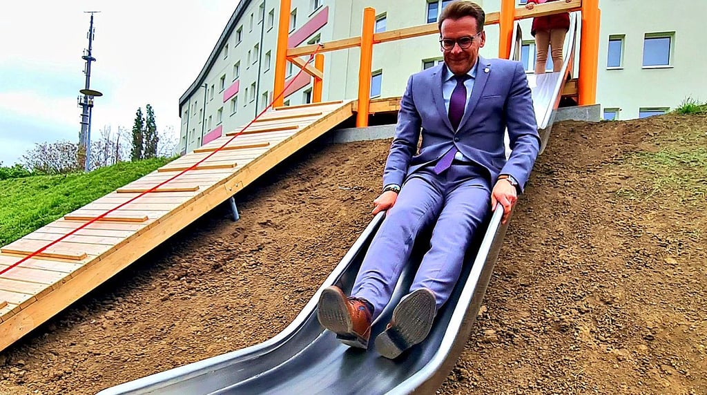 Wernigerodes Oberbürgermeister Tobias Kascha (SPD) testet die neue Rutsche im Wohngebiet Stadtfeld.