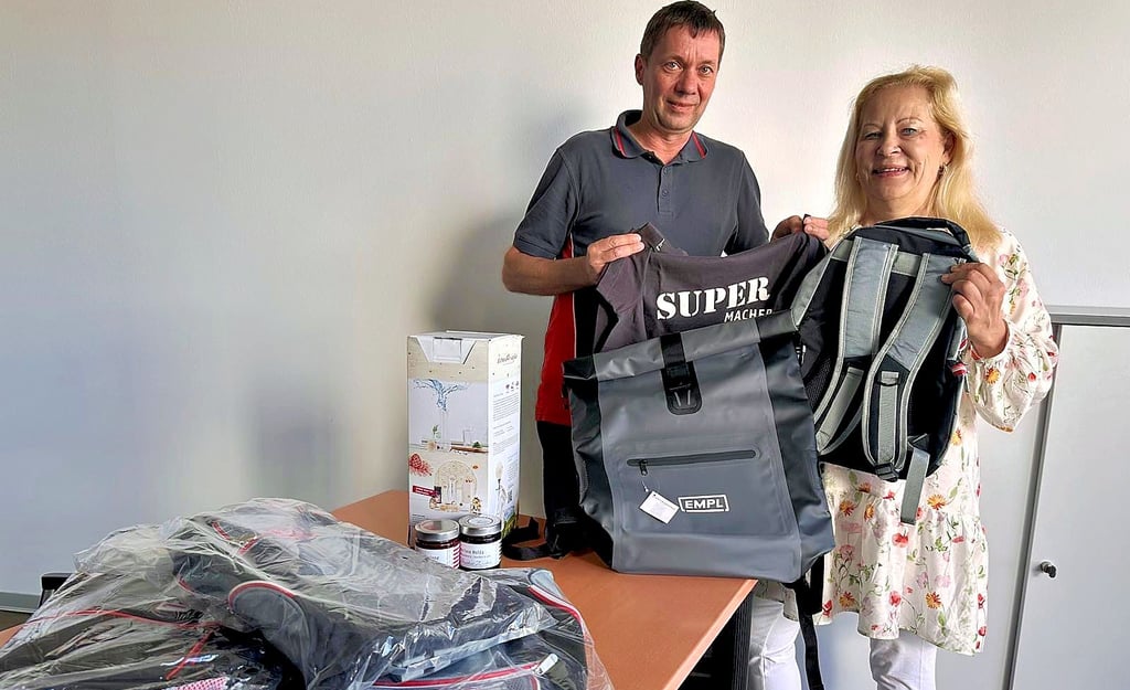 Thomas Winkler, Betriebsleiter bei Empl, überreicht Sabine Hoffmann, Leiterin des Jugendclubs „Zuflucht“ in Elster, Auktionsobkjekte. Es sind Spenden, die zur Finanzierung des zehnten Zeltlagers in Elster versteigert werden sollen.