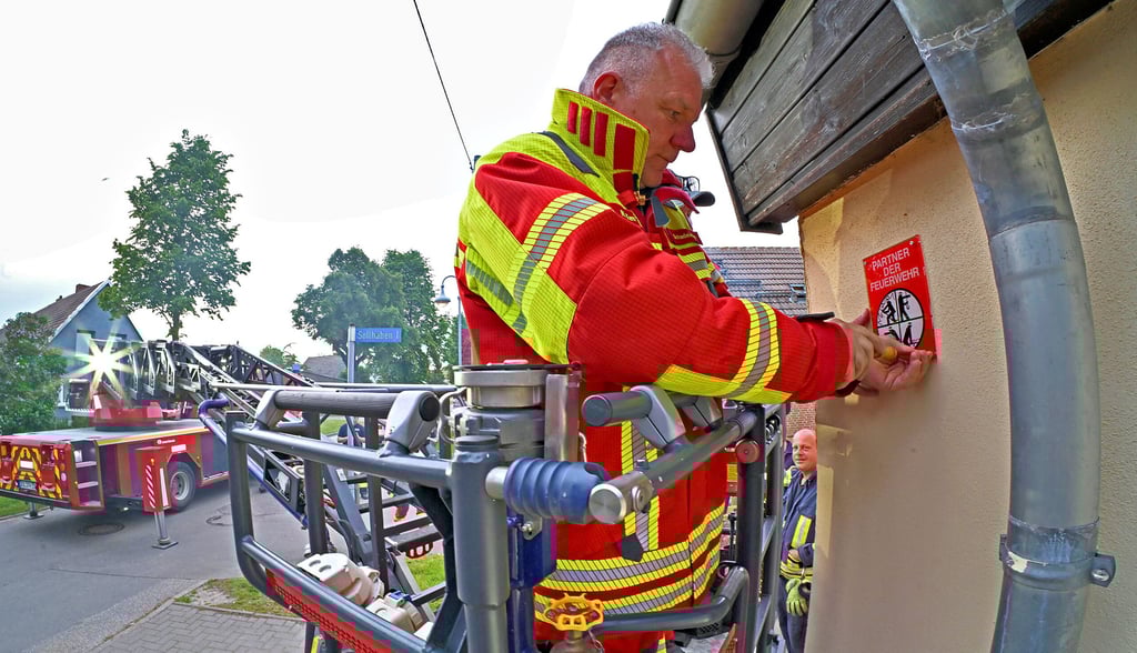 Die Plakette „Partner der Feuerwehr“ wird angebracht.