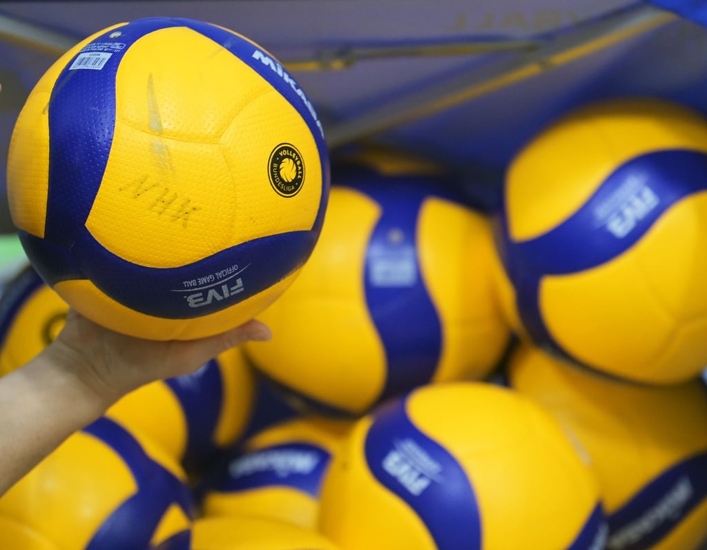 Volleybälle liegen in einer Halle.