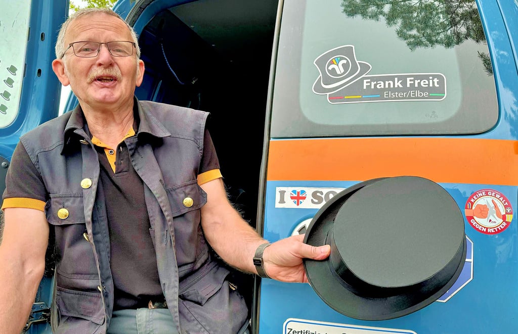 Bezirksschornsteinfegermeister Frank Freit aus Elster weist mit seinem Zylinder auf den Aufkleber „Keine Gewalt gegen Retter“ hin.