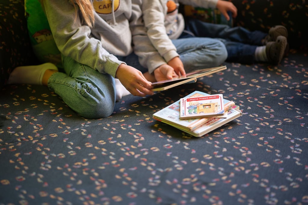 Eine Praktikantin liest in einer Kita Kindern vor.