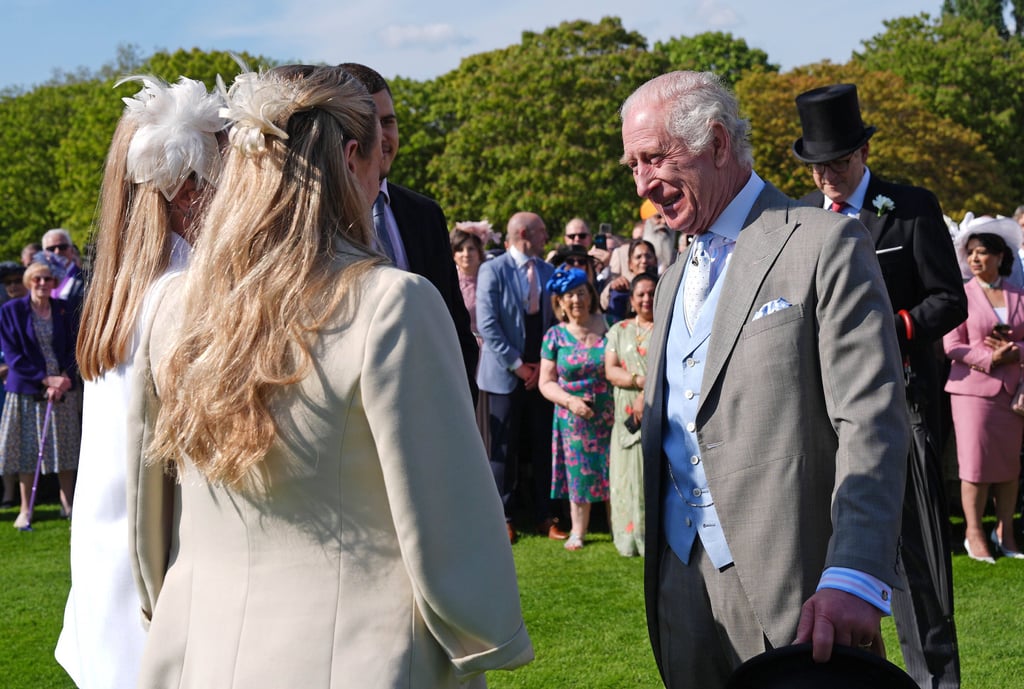 König Charles unterhält sich mit Gästen. 