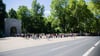 Eine lange Schlange bildet sich entlang der Puschkinallee vor den Einlasskontrollen zum Sowjetischen Ehrenmal im Treptower Park.
