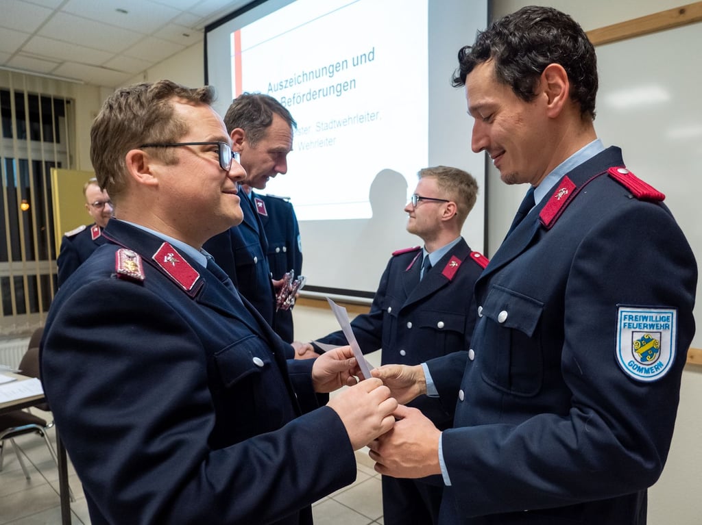 Der nun zum Stadtwehrleiter gewählte Steven Vonend (l.) überreicht Auszeichungen an Kameradinnen und Kameraden der Freiwilligen Feuerwehr in Gommern.