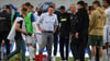 Magdeburgs Trainer Christian Titz steht nach dem Spiel bei seinen Spielern auf dem Feld.