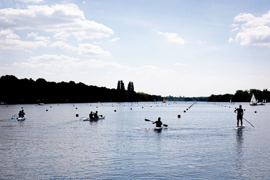 Menschen sind am Vatertag bei sonnigem Wetter mit Kanu, Stand-up-Paddle-Board und Booten auf dem Maschsee unterwegs.